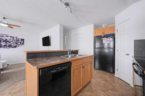 102-800 Yankee Valley Boulevard Se, Airdrie, AB - Indoor Photo Showing Kitchen With Double Sink