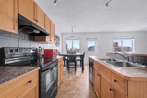 102-800 Yankee Valley Boulevard Se, Airdrie, AB - Indoor Photo Showing Kitchen With Double Sink