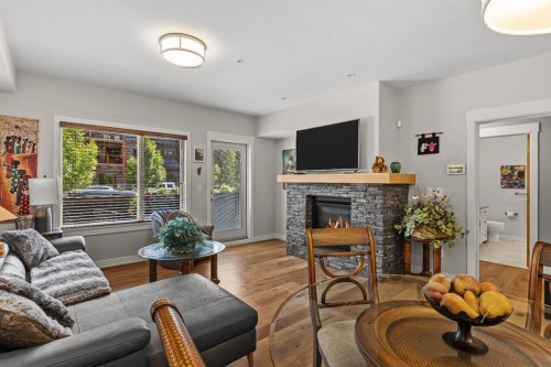 102-707 Spring Creek Drive, Canmore, AB - Indoor Photo Showing Living Room With Fireplace