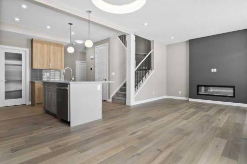 67 Agate Road, Cochrane, AB - Indoor Photo Showing Kitchen With Fireplace With Upgraded Kitchen