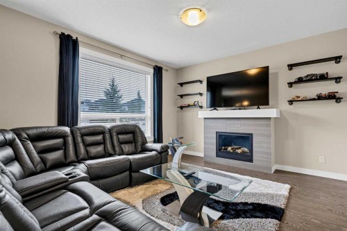 1701-1086 Williamstown Boulevard Nw, Airdrie, AB - Indoor Photo Showing Living Room With Fireplace