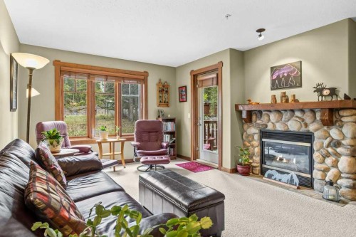 215-150 Crossbow Place, Canmore, AB - Indoor Photo Showing Living Room With Fireplace