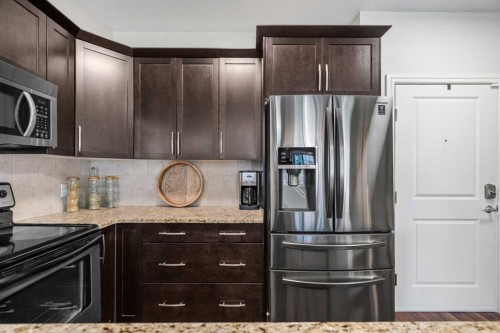 3106-15 Sunset Square, Cochrane, AB - Indoor Photo Showing Kitchen With Stainless Steel Kitchen With Upgraded Kitchen