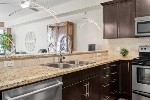 3106-15 Sunset Square, Cochrane, AB - Indoor Photo Showing Kitchen With Stainless Steel Kitchen With Double Sink With Upgraded Kitchen