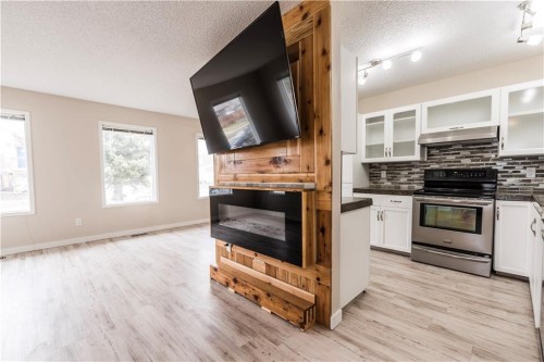 1019 Smith Avenue, Crossfield, AB - Indoor Photo Showing Kitchen With Fireplace
