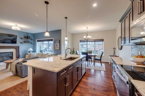 150 Fireside Bend, Cochrane, AB - Indoor Photo Showing Kitchen With Fireplace With Double Sink With Upgraded Kitchen