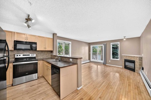 3109-70 Panamount Drive Nw, Calgary, AB - Indoor Photo Showing Kitchen With Fireplace With Double Sink