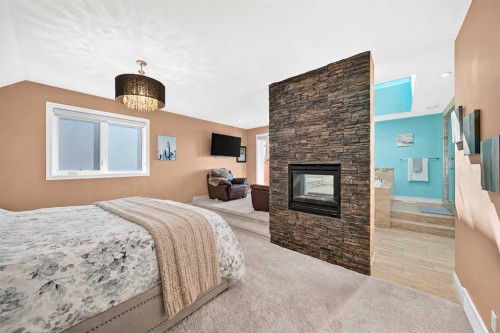 116 Panatella Rise Nw, Calgary, AB - Indoor Photo Showing Bedroom With Fireplace