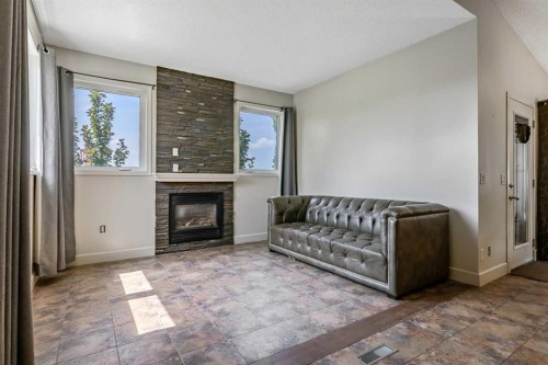443 Riverside Green Nw, High River, AB - Indoor Photo Showing Living Room With Fireplace