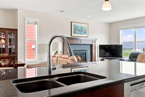 14 Ridge View Place, Cochrane, AB - Indoor Photo Showing Kitchen With Fireplace With Double Sink