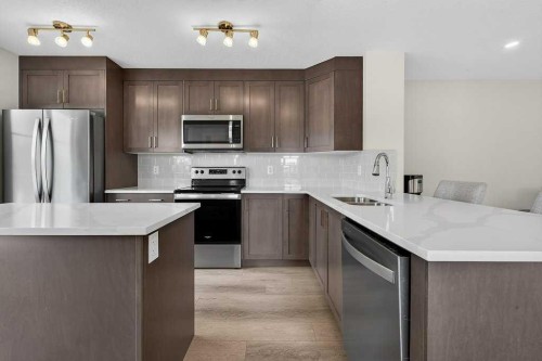 709-474 Seton Circle Se, Calgary, AB - Indoor Photo Showing Kitchen With Stainless Steel Kitchen With Double Sink With Upgraded Kitchen