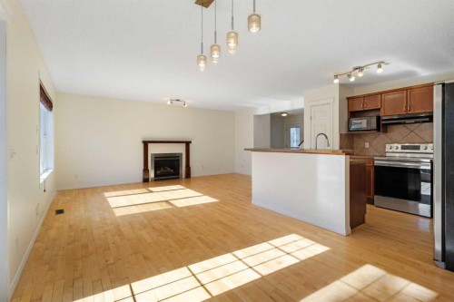 78 Cougar Plateau Way Sw, Calgary, AB - Indoor Photo Showing Kitchen With Fireplace
