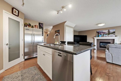46 Spring View Sw, Calgary, AB - Indoor Photo Showing Kitchen With Fireplace With Double Sink