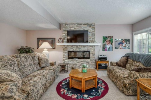 61 River Heights View, Cochrane, AB - Indoor Photo Showing Living Room With Fireplace