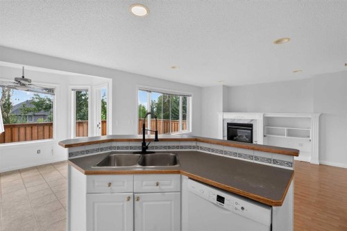 126 Bridlewood Way Sw, Calgary, AB - Indoor Photo Showing Kitchen With Fireplace With Double Sink