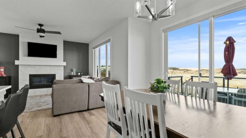 152 Threepoint Cove, Okotoks, AB - Indoor Photo Showing Dining Room With Fireplace