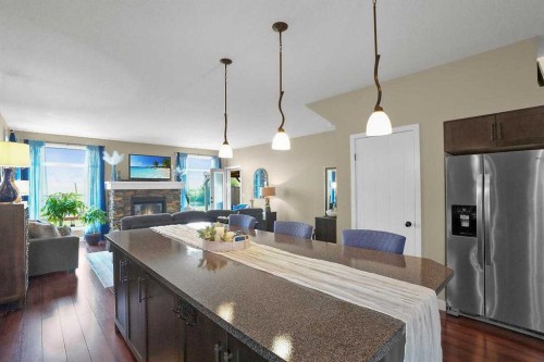 460 Seclusion Valley Drive, Diamond Valley, AB - Indoor Photo Showing Kitchen With Fireplace