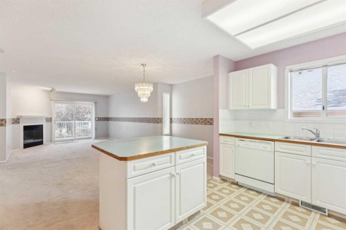 134 Hawkstone Manor Nw, Calgary, AB - Indoor Photo Showing Kitchen With Fireplace With Double Sink