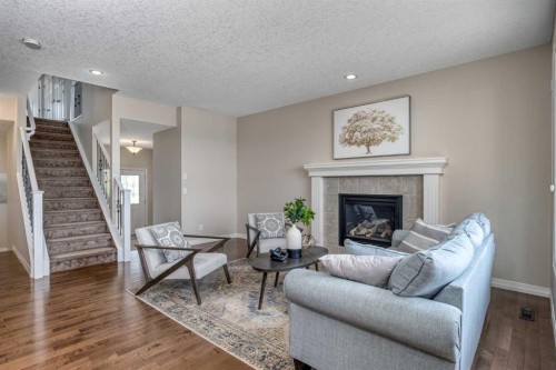 128 Sunset Park, Cochrane, AB - Indoor Photo Showing Living Room With Fireplace