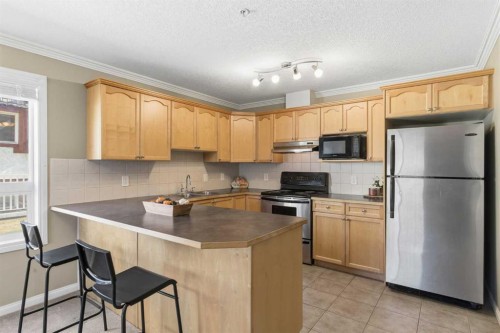 103-128 Centre Avenue, Cochrane, AB - Indoor Photo Showing Kitchen With Double Sink