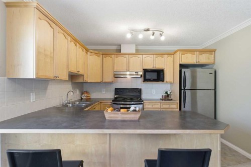 103-128 Centre Avenue, Cochrane, AB - Indoor Photo Showing Kitchen With Double Sink