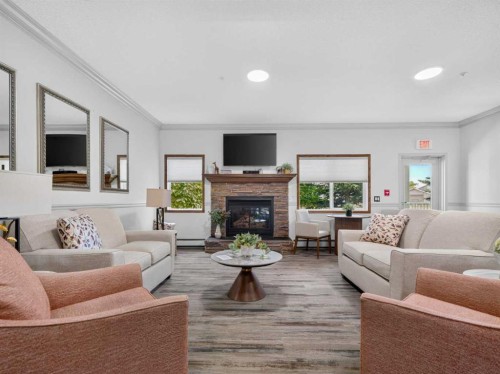 201-72 Quigley Drive, Cochrane, AB - Indoor Photo Showing Living Room With Fireplace
