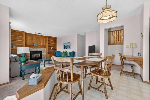 105 Christie Knoll Heights Sw, Calgary, AB - Indoor Photo Showing Dining Room With Fireplace