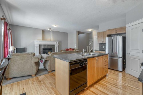 177 Cougartown Circle Sw, Calgary, AB - Indoor Photo Showing Kitchen With Fireplace With Double Sink
