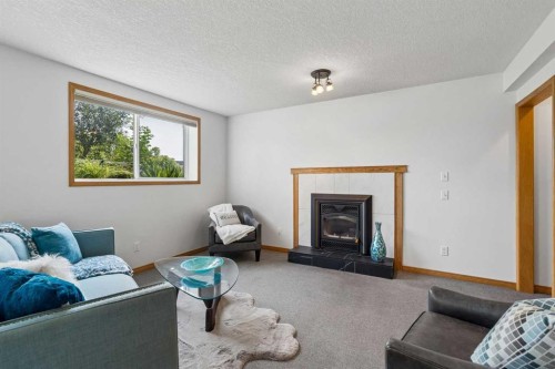 246 Mt Lorette Place Se, Calgary, AB - Indoor Photo Showing Living Room With Fireplace