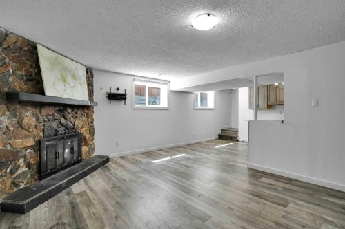 1015 Maitland Way Ne, Calgary, AB - Indoor Photo Showing Other Room With Fireplace