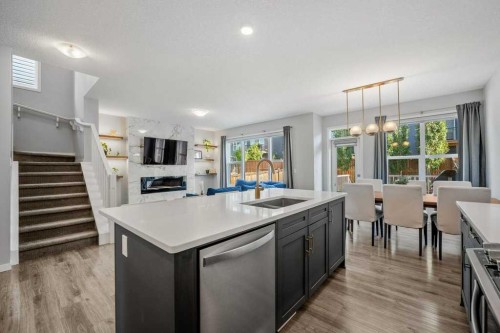 114 Crestbrook Way Sw, Calgary, AB - Indoor Photo Showing Kitchen With Fireplace With Double Sink