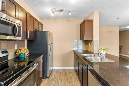 7202-403 Mackenzie Way Sw, Airdrie, AB - Indoor Photo Showing Kitchen With Stainless Steel Kitchen With Double Sink With Upgraded Kitchen