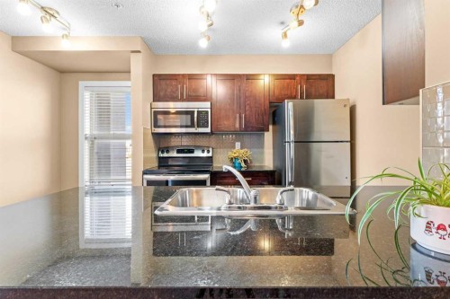 7202-403 Mackenzie Way Sw, Airdrie, AB - Indoor Photo Showing Kitchen With Stainless Steel Kitchen With Double Sink