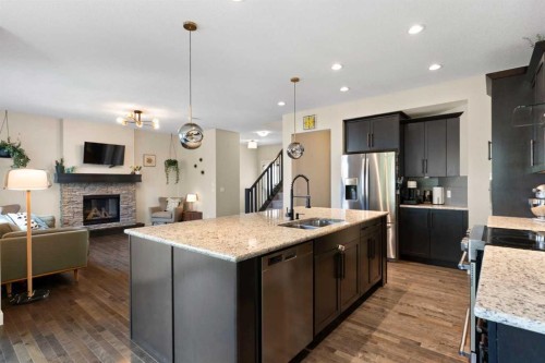434 River Heights Drive, Cochrane, AB - Indoor Photo Showing Kitchen With Fireplace With Stainless Steel Kitchen With Double Sink With Upgraded Kitchen