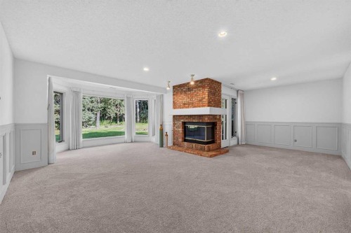 12 Sunset Way, Priddis Greens, AB - Indoor Photo Showing Other Room With Fireplace