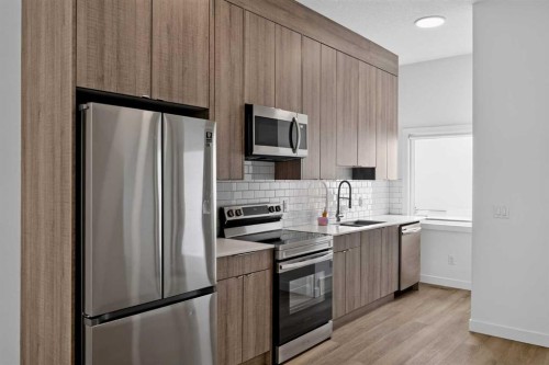 202-101 Panatella Square Nw, Calgary, AB - Indoor Photo Showing Kitchen With Stainless Steel Kitchen With Upgraded Kitchen