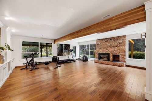 15 Elbow River Point, Rural Rocky View County, AB - Indoor Photo Showing Gym Room With Fireplace