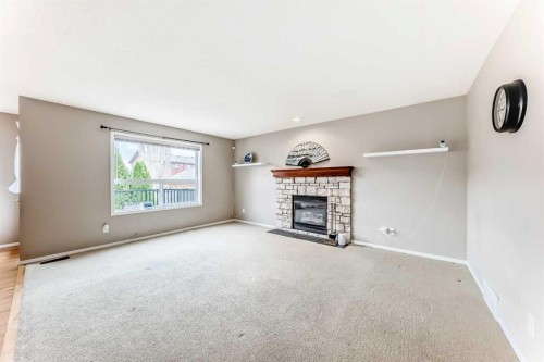 80 Eversyde Way Sw, Calgary, AB - Indoor Photo Showing Living Room With Fireplace