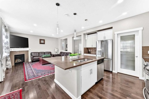 56 Evansborough Green Nw, Calgary, AB - Indoor Photo Showing Kitchen With Fireplace With Stainless Steel Kitchen With Double Sink With Upgraded Kitchen