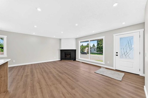 704 Malvern Drive Ne, Calgary, AB - Indoor Photo Showing Other Room With Fireplace