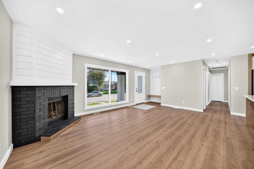 704 Malvern Drive Ne, Calgary, AB - Indoor Photo Showing Living Room With Fireplace