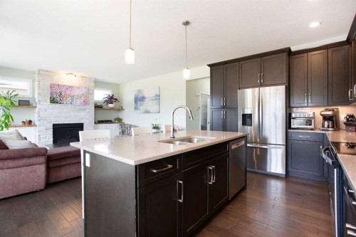 87 Baywater Rise Sw, Airdrie, AB - Indoor Photo Showing Kitchen With Fireplace With Double Sink