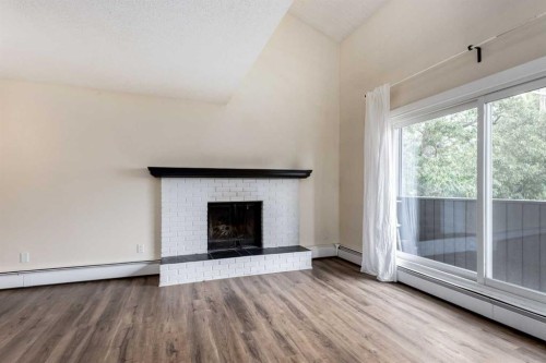 303-730 2 Avenue Nw, Calgary, AB - Indoor Photo Showing Living Room With Fireplace