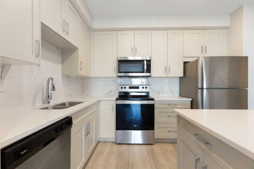 202-150 Shawnee Square Sw, Calgary, AB - Indoor Photo Showing Kitchen With Stainless Steel Kitchen With Double Sink With Upgraded Kitchen