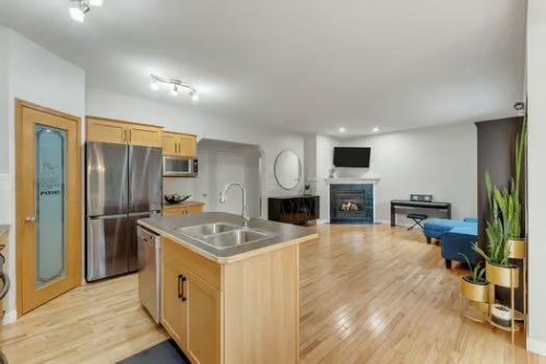 100 Fairways Drive Nw, Airdrie, AB - Indoor Photo Showing Kitchen With Fireplace With Double Sink