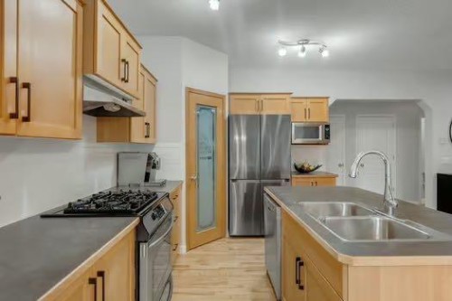 100 Fairways Drive Nw, Airdrie, AB - Indoor Photo Showing Kitchen With Double Sink