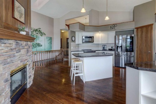 321 Gleneagles View, Cochrane, AB - Indoor Photo Showing Kitchen With Fireplace