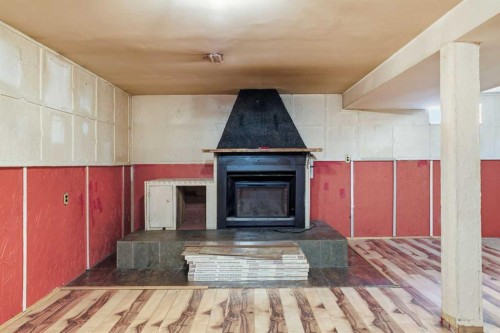 7807 Olympia Bay Se, Calgary, AB - Indoor Photo Showing Other Room With Fireplace