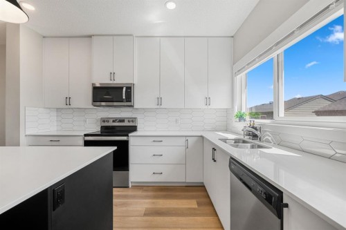 102 Midgrove Sw, Airdrie, AB - Indoor Photo Showing Kitchen With Stainless Steel Kitchen With Double Sink With Upgraded Kitchen
