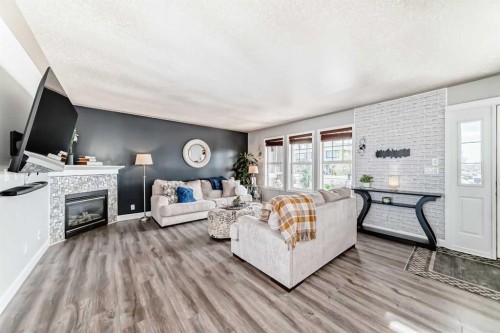 22 Moe Avenue Nw, Langdon, AB - Indoor Photo Showing Living Room With Fireplace